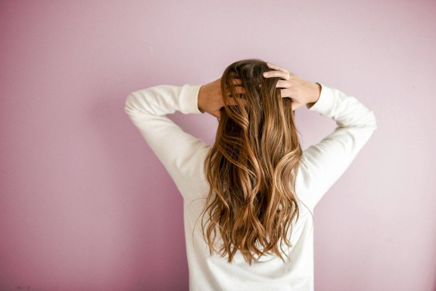 Long, softly textured hair against a rose-pink backdrop