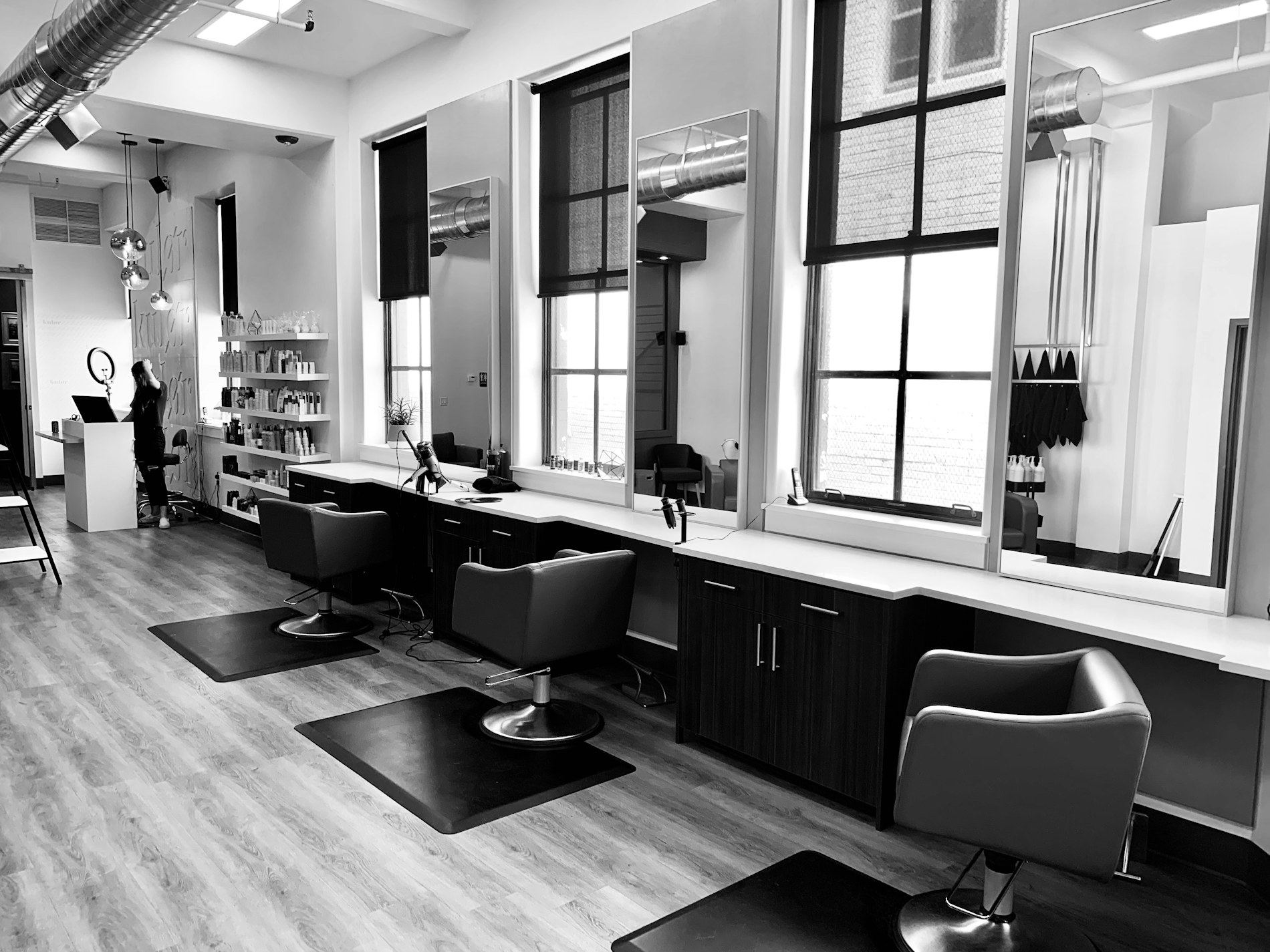 A light-filled hair studio with tall windows and styling chairs